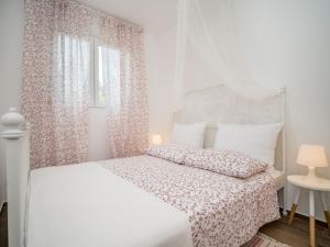 a white bedroom with a white bed and a window at Holiday Home Ofelia by Interhome in Buroli