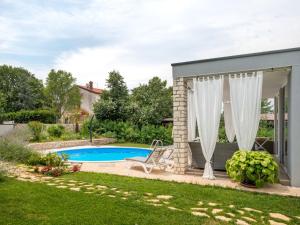 a garden with a swimming pool and a house at Holiday Home Ofelia by Interhome in Buroli