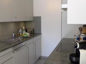 a kitchen with white cabinets and a sink at Apartment Chesa Sur Ova 21 by Interhome in St. Moritz