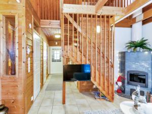 ein Wohnzimmer mit Holzwänden und einem Kamin in der Unterkunft Holiday Home Saunaharju 3 by Interhome in Kolinkylä