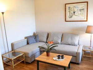 ein Wohnzimmer mit einem Sofa und einem Tisch in der Unterkunft Apartment Le Polo by Interhome in Deauville
