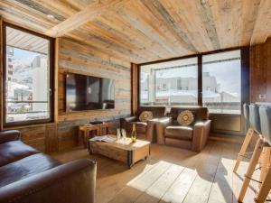 a living room with leather couches and a tv at Apartment Les Grandes Platières-23 by Interhome in Tignes