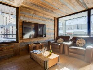 a living room with a couch and a tv at Apartment Les Grandes Platières-23 by Interhome in Tignes