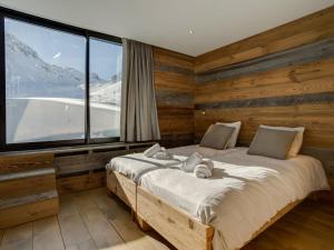 ein Schlafzimmer mit einem Bett und einem großen Fenster in der Unterkunft Apartment Les Grandes Platières-23 by Interhome in Tignes