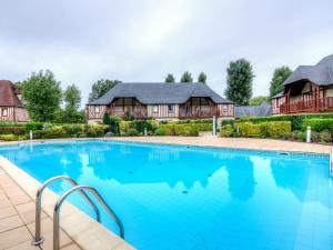 a large swimming pool in front of a house at Holiday Home Domaine de Clairefontaine-2 by Interhome in Deauville