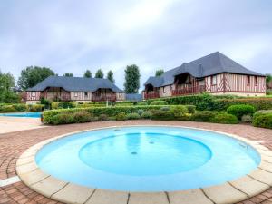 a house with a large pool in front of a house at Holiday Home Domaine de Clairefontaine-2 by Interhome in Deauville