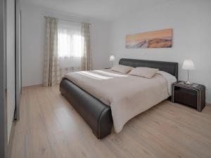 a bedroom with a bed with a black leather bed frame at Apartment Lucia-1 by Interhome in Kmeti
