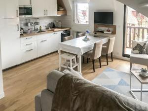 a kitchen and living room with a table and a couch at Apartment Le Fairway-5 by Interhome in Deauville