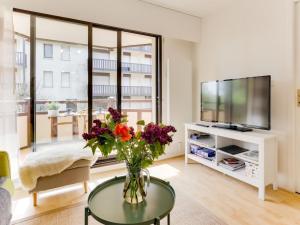 a living room with a vase of flowers on a table at Apartment Le Fairway-6 by Interhome in Deauville