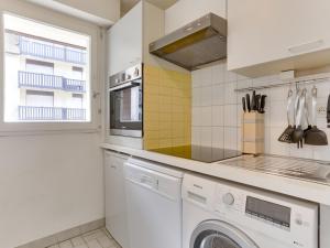 a white kitchen with a washer and dryer at Apartment Le Fairway-6 by Interhome in Deauville +15 photos