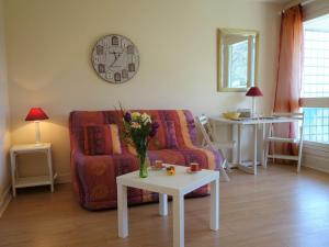 sala de estar con sofá y mesa con flores. en Studio Le Parc de la Chaumière-5 by Interhome, en Trouville-sur-Mer