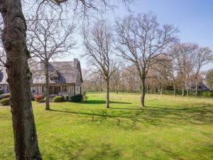 a house in a field with trees in the foreground at Apartment Les Hauts de Deauville-1 by Interhome in Saint-Arnoult