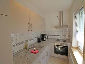 a white kitchen with a sink and a stove at Apartment Eifelnatur - Haus 3-2 by Interhome in Immerath