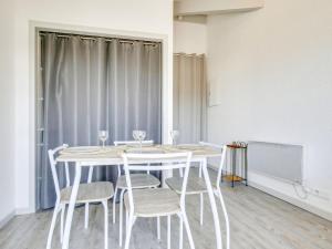 een witte eetkamer met een tafel en stoelen bij Studio La Passerelle by Interhome in Gujan-Mestras