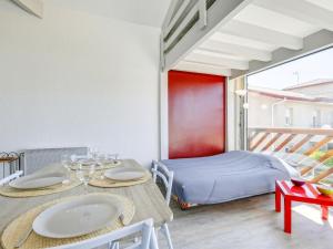 een kamer met 2 tafels en een bed op een balkon bij Studio La Passerelle by Interhome in Gujan-Mestras
