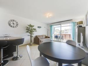 uma sala de estar com uma mesa preta e cadeiras em Apartment Beau Rivage-3 by Interhome em Cavalaire-sur-Mer