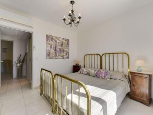 a bedroom with a bed and a chandelier at Apartment Les Terrasses de Grimaud by Interhome in Grimaud