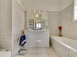 a bathroom with a tub and a sink at Apartment Les Terrasses de Grimaud by Interhome in Grimaud