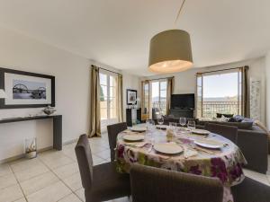 a dining room with a table and chairs and a living room at Apartment Les Terrasses de Grimaud by Interhome in Grimaud