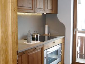 a kitchen with wooden cabinets and a stove top oven at Apartment Chesa Sonnalpine B 48-4 by Interhome in St. Moritz