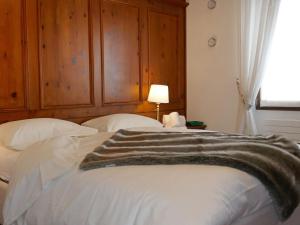 a bedroom with a bed with a blanket on it at Apartment Chesa Sonnalpine B 48-4 by Interhome in St. Moritz +28 photos