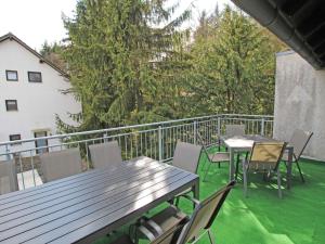 a patio with tables and chairs on a balcony at Apartment Eifelnatur - Haus 2-3 by Interhome in Immerath