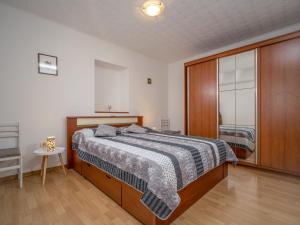 um quarto com uma cama e um armário de madeira em Apartment Bumbak by Interhome em Umag