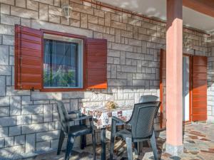 a patio with a table and chairs in front of a stone wall at Apartment Bumbak by Interhome in Umag