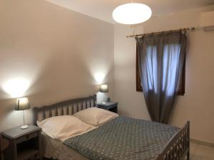 1 dormitorio con 1 cama con 2 mesas y 2 lámparas en Gîte La Maison de Huguette et Lucien, en Le Vigan