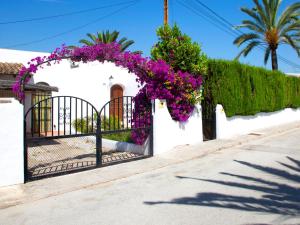 a gate with a bunch of purple flowers on it at Holiday Home Rafol by Interhome in Calpe