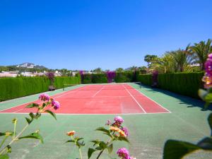 a tennis court with purple flowers on it at Holiday Home Rafol by Interhome in Calpe