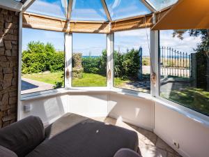 sala de estar con ventanas grandes y sofá en Holiday Home Villa Pieds Dans l'Eau Enez Thinic by Interhome, en Saint-Pierre-Quiberon