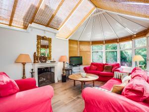 uma sala de estar com sofás vermelhos e uma televisão em Holiday Home Villa Pieds Dans l'Eau Enez Thinic by Interhome em Saint-Pierre-Quiberon