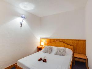 Un dormitorio con una cama con dos zapatos. en Apartment Le Schuss - Val Claret-5 by Interhome en Tignes