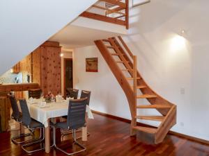 una sala da pranzo con tavolo e scala di Apartment Chesa Polaschin E - E21 - Sils by Interhome a Sils Maria