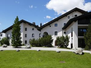 ein großes weißes Gebäude mit einem Rasen davor in der Unterkunft Apartment Chesa Polaschin E - E21 - Sils by Interhome in Sils Maria