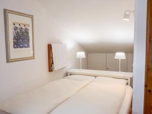 ein weißes Schlafzimmer mit 2 Betten und 2 Lampen in der Unterkunft Apartment Chesa Polaschin E - E21 - Sils by Interhome in Sils Maria