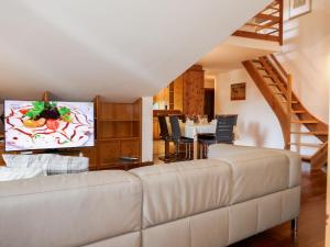 un soggiorno con divano bianco e scala di Apartment Chesa Polaschin E - E21 - Sils by Interhome a Sils Maria