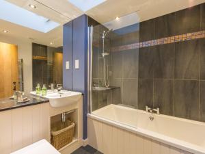 a bathroom with a tub and a sink and a bath tub at Holiday Home The Hayloft by Interhome in Edinburgh