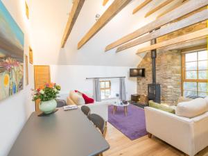 a living room with a table and chairs and a fireplace at Holiday Home The Hayloft by Interhome in Edinburgh