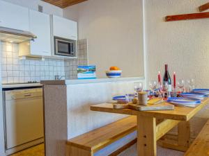 a kitchen with a wooden table with wine glasses at Apartment Les Hauts du Val Claret - Val Claret-22 by Interhome in Tignes