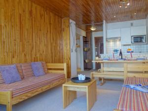 a living room with a couch and a kitchen at Apartment Les Hauts du Val Claret - Val Claret-22 by Interhome in Tignes