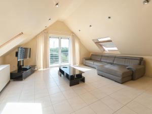 a living room with a couch and a tv at Apartment Goldsands II 402 Top floor with parking by Interhome in De Haan