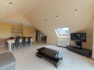 a living room with a television and a dining room at Apartment Goldsands II 402 Top floor with parking by Interhome in De Haan