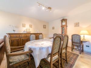 a dining room with a table and chairs and a clock at Apartment Goldsands II 101 with garage by Interhome in De Haan +11 photos