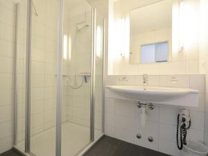 a white bathroom with a sink and a shower at Apartment Surses Alpin-3 by Interhome in Savognin