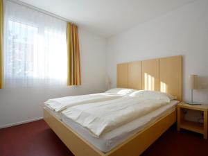 a large bed in a room with a window at Apartment Surses Alpin-3 by Interhome in Savognin +43 photos