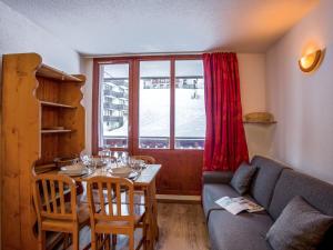 a living room with a table and a couch and a window at Studio Rond Point des Pistes-12 by Interhome in Tignes