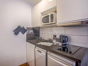 a small kitchen with a sink and a microwave at Studio Rond Point des Pistes-12 by Interhome in Tignes