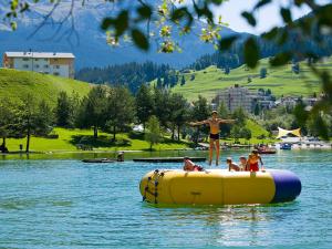 Eine Frau, die auf einem Floß im Wasser steht. in der Unterkunft Apartment Surses Alpin-1 by Interhome in Savognin